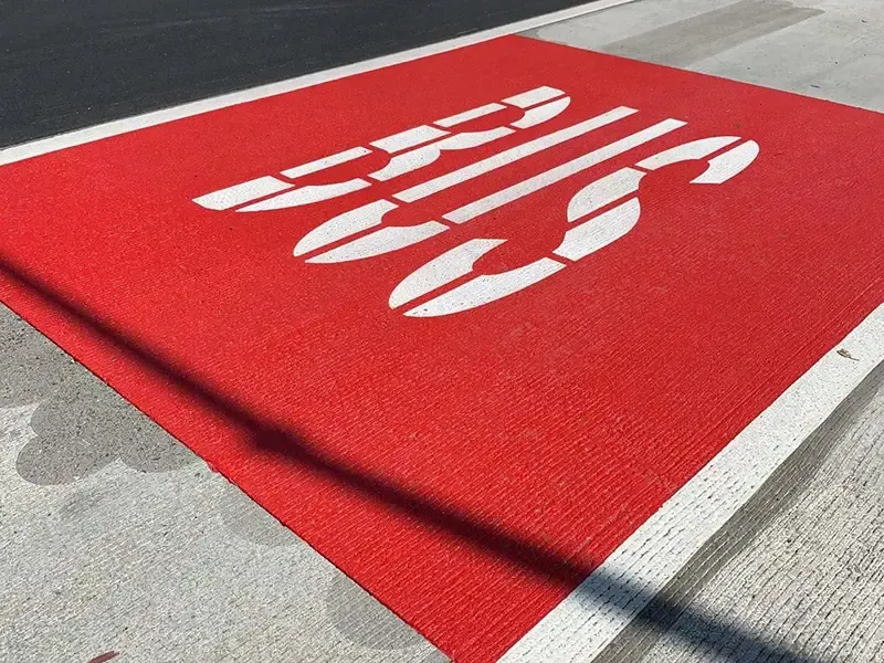 Red bus lane coating with white BUS lettering