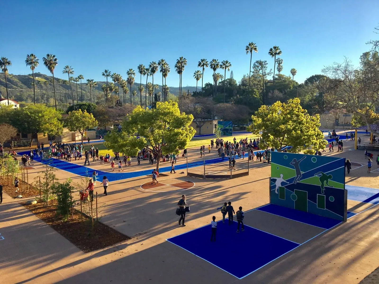 School campus plaza with blue coated walkways and courts seen from above